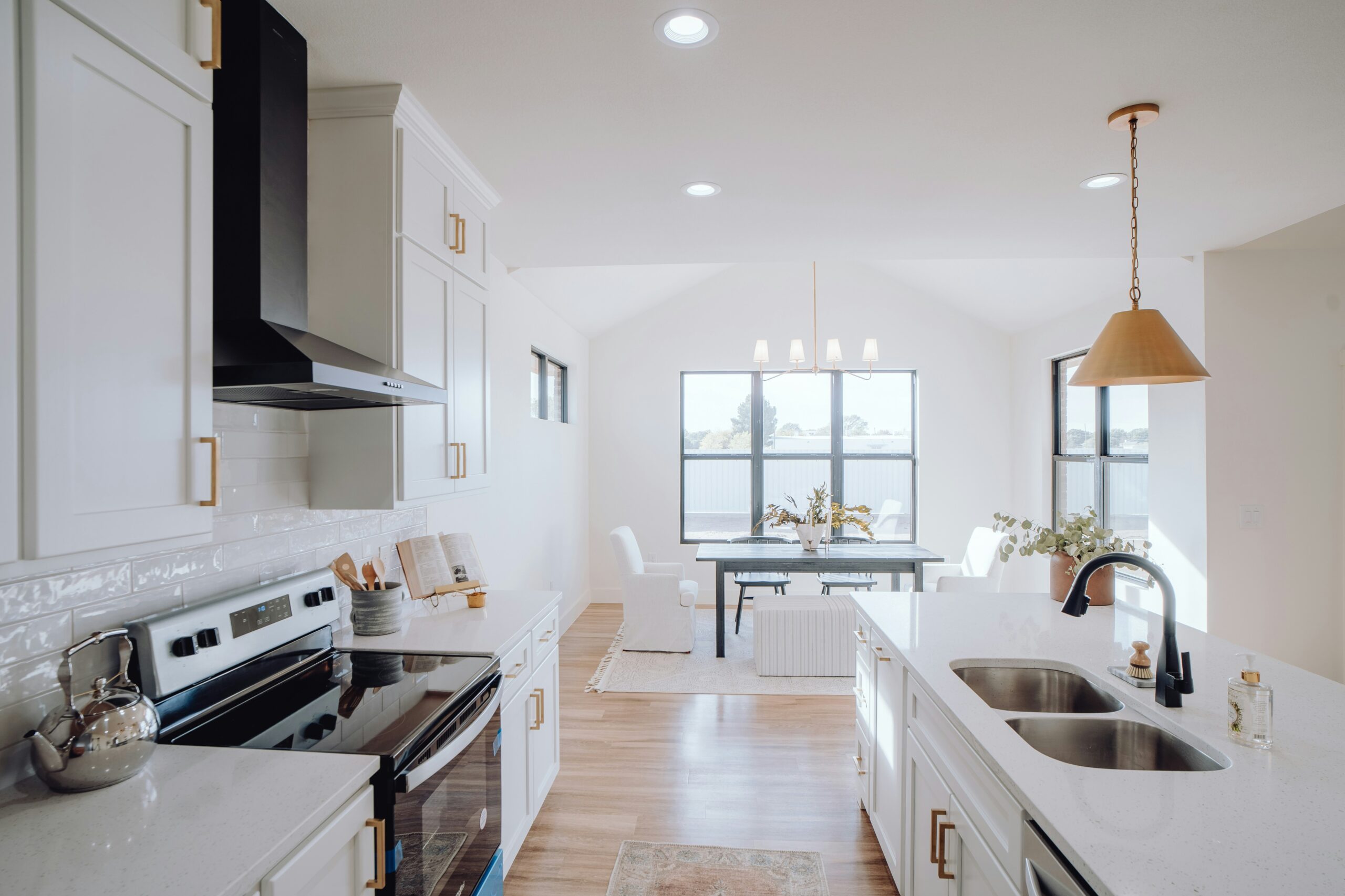 a kitchen with a sink, stove, and a window