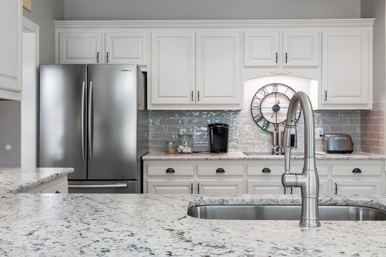 A kitchen with white cabinets and stainless steel appliances