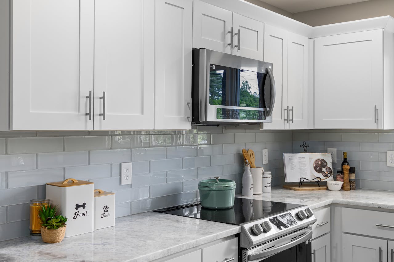 A kitchen with white cabinets and a microwave