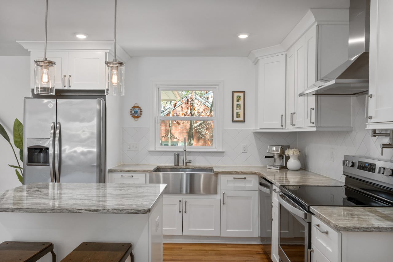 A kitchen with white cabinets and stainless steel appliances