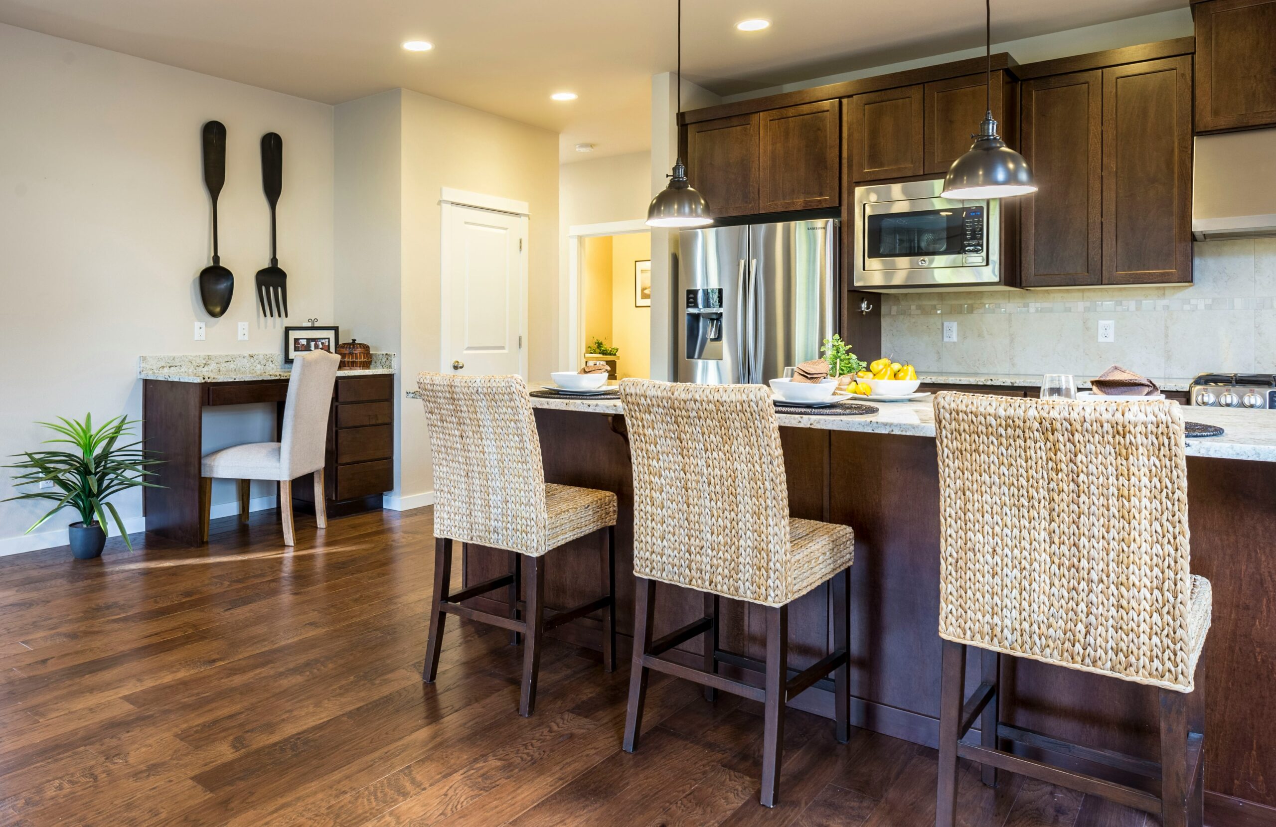 three brown wooden chairs in front of kitchen counter